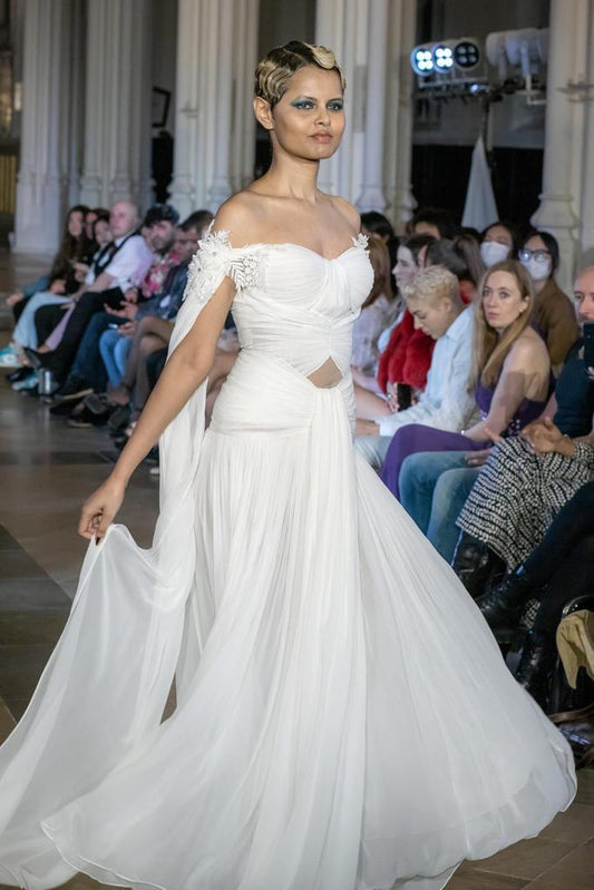 Elegant White Off-Shoulder Gown with Chiffon Drape and Modern Cut-Out Detail